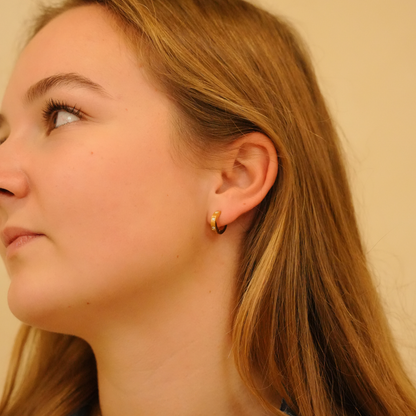 Gold hoop earrings with stones by [Vendor name] on a model, side view.