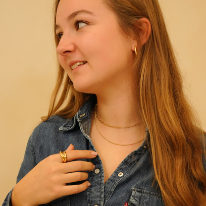 Fine beaded necklace with gold tone finish, plus a gold ring and hoop earrings.