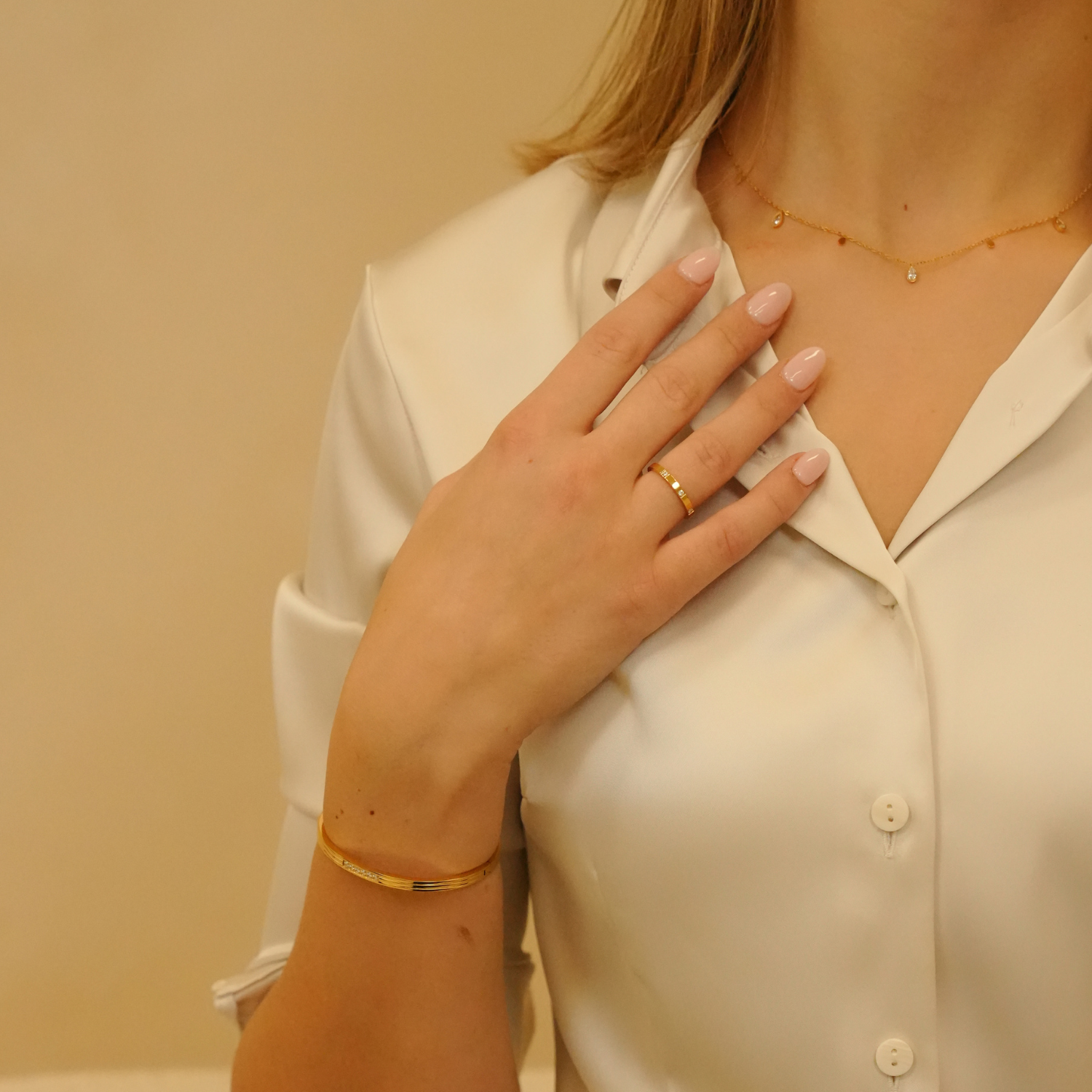 Gold necklace with sparkle drops, accented with gold ring and bracelet.