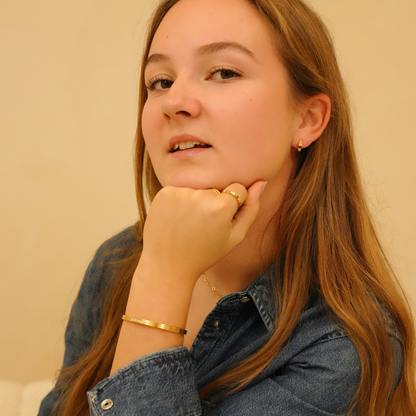 Gold six stone bracelet from an unknown brand, worn with a denim shirt and rings.